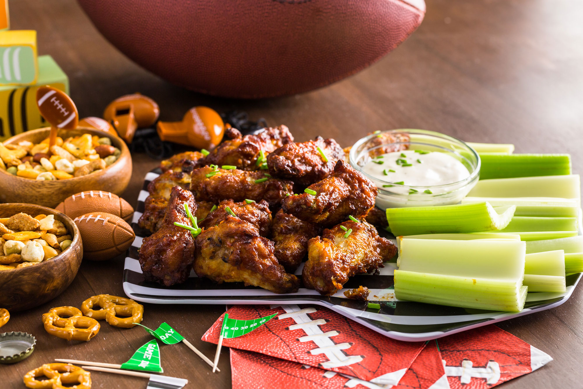 A platter of chicken wings, celery, snack mix and dipping sauce