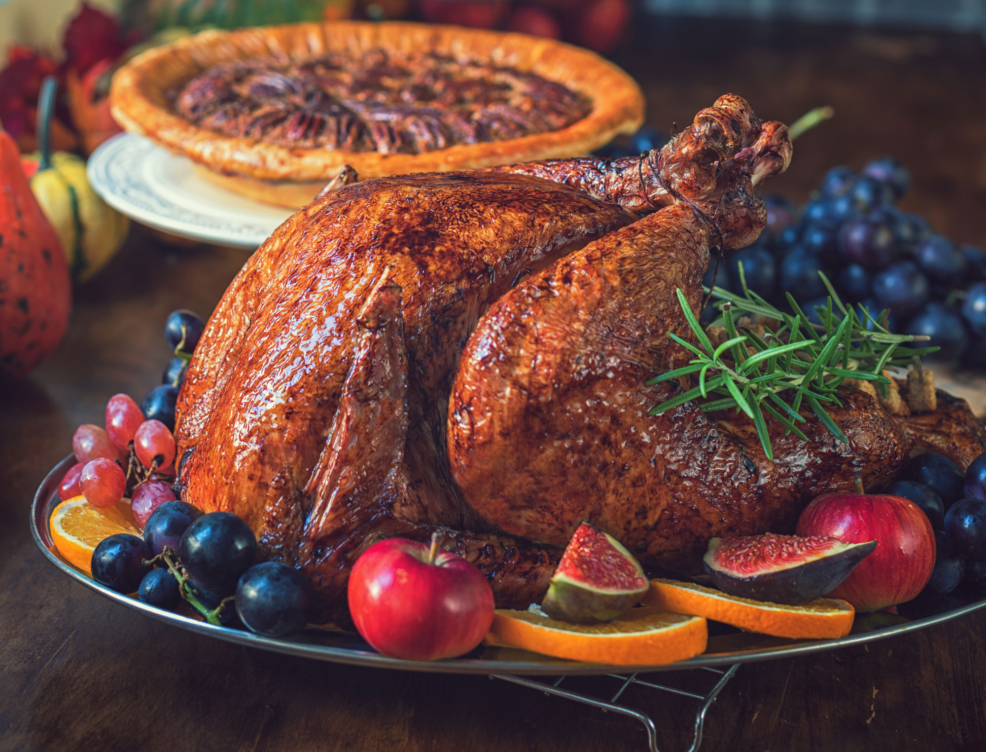 A turkey and a pie with different fruits on plates