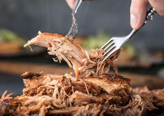 A person shredding pork