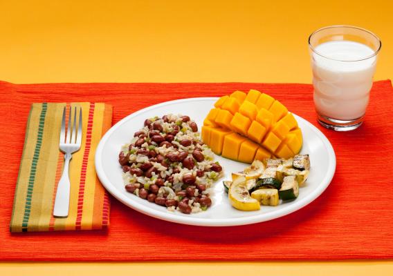 A plate of food and a glass of milk on a mat