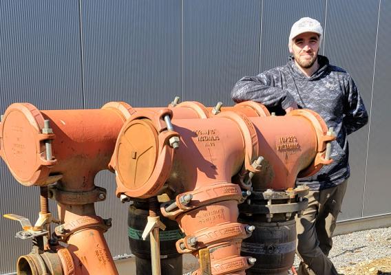 Maintenance Manager Steve Case for Little Leaf Farms in Massachusetts pictured next to input hookups for the greenhouse chiller