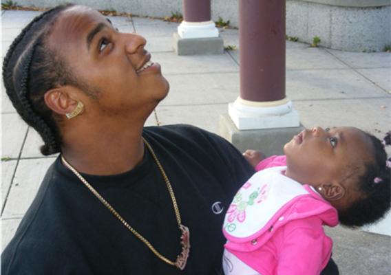 Father and daughter watching birds fly overhead