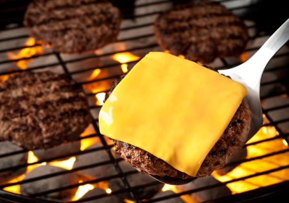 A burger with cheese on the grill