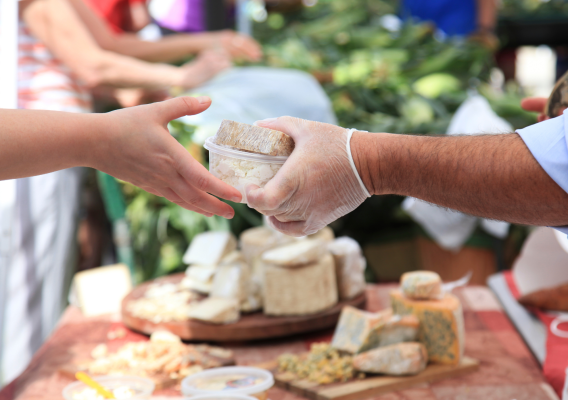 A person handing cheese to another person