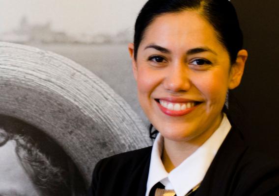 Equity Commission Member Dr. Loza in front of museum exhibit