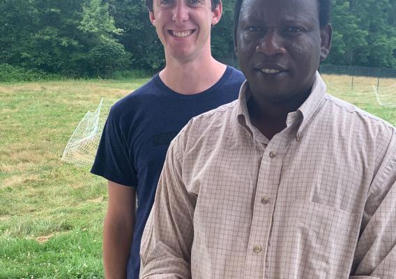 Somali Bantu Community Association of Maine Executive Director Muhidin Libah stands with SBCA Intern Holden Turner on farmland