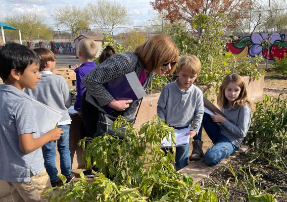 Food and Nutrition Service Administrator Cindy Long and kids overlook a garden in McCaw STEAM Academy located in Las Vegas, Nevada