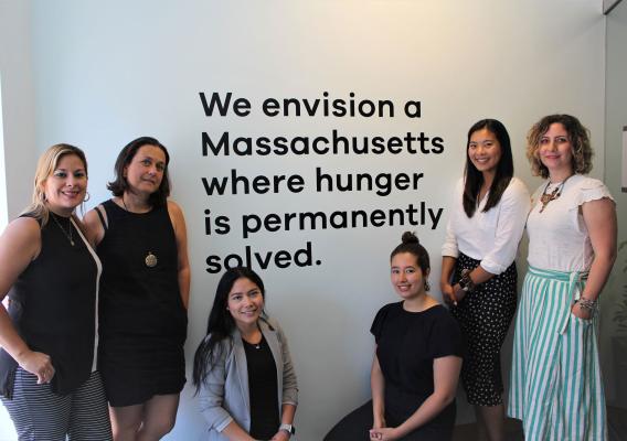 Project Bread’s Flexible Services Program Office Team stands near statement on the wall that reads, “We envision a Massachusetts where huger is permanently solved.”