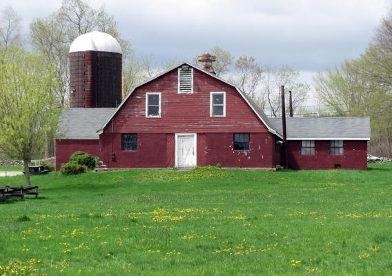 A rustic red barn on a New England farm in spring