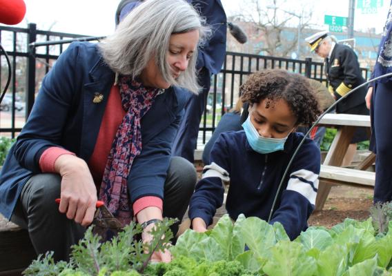 FNCS Deputy Under Secretary Stacy Dean harvests collard greens from the Watkins Elementary School garden with 5th grade student