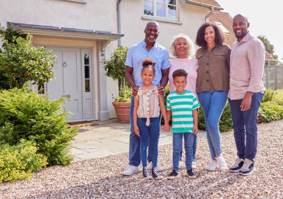 Family stands in front of their home